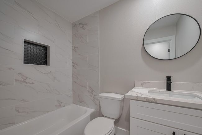 Thoughtfully designed second bath includes a sleek vanity with storage below, coordinating finishes, and a tub-shower combo that blends function and clean style. | Image 24