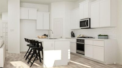 Kitchen with a center island with sink, appliances with stainless steel finishes, white cabinetry, light wood-type flooring, and sink | Image 3