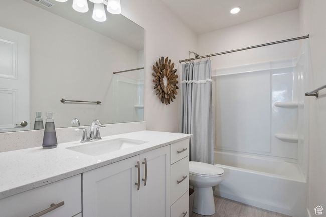 Bathroom featuring vanity, shower / tub combo, wood finished floors, and recessed lighting | Image 22