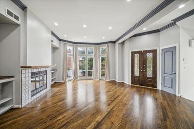 Living room with fireplace 1 of 3, double door entry, coat closet and wet bar located to the left of the fireplace. | Image 2