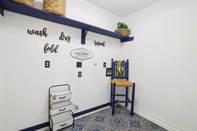This laundry room features a bright, clean design with white walls and blue accents. | Image 15