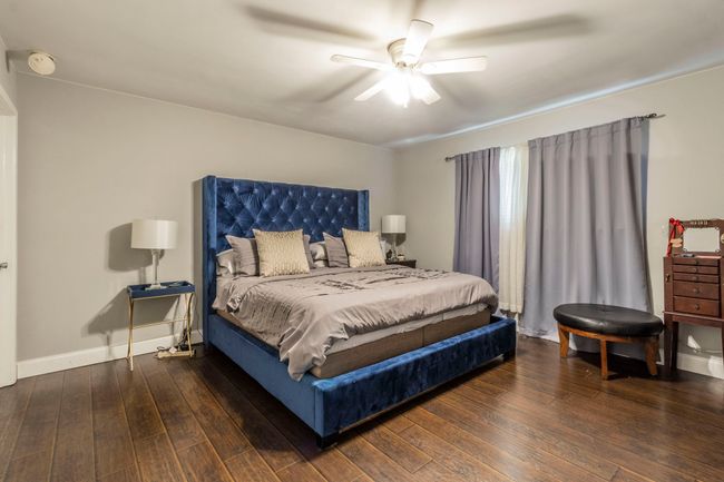 Bedroom with hardwood / wood-style floors, baseboards, and a ceiling fan | Image 12
