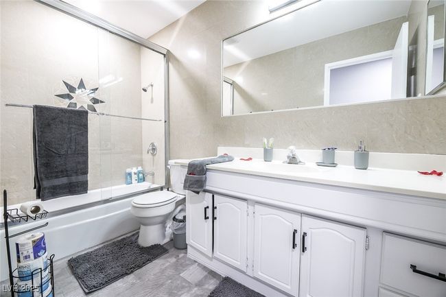 Bathroom with toilet, enclosed tub / shower combo, and vanity | Image 29