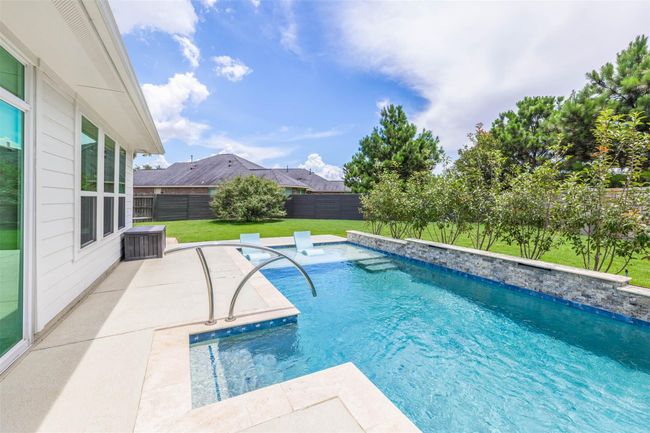 From this angle, the pool's sparkling waters catch the light beautifully, while the surrounding landscape and elegant design features create a serene and luxurious ambiance. The view highlights the pool's harmonious integration with its environment. | Image 34