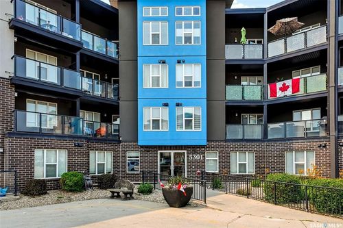 Contemporary multi-story building featuring a brick base and vibrant blue and charcoal facade | Card Image