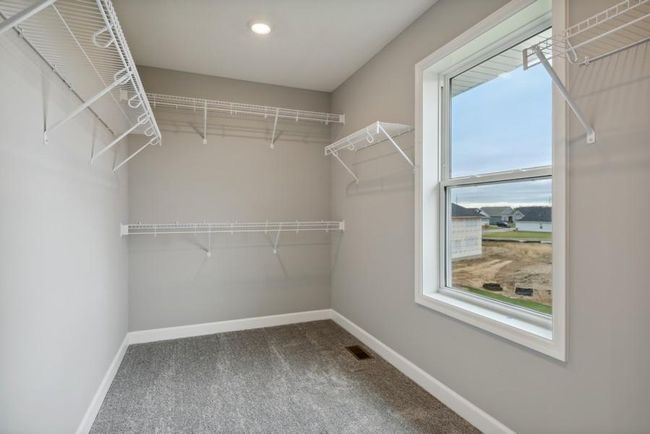 (Photo is of an inventory home, actual homes finishes will vary) The second walk-in closet featured in the primary suite. Plus, this one features a wonderful closet window, a perfect way to brighten up everyday. | Image 16