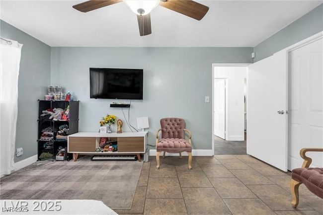 Living area with a ceiling fan, baseboards, and tile patterned floors | Image 15