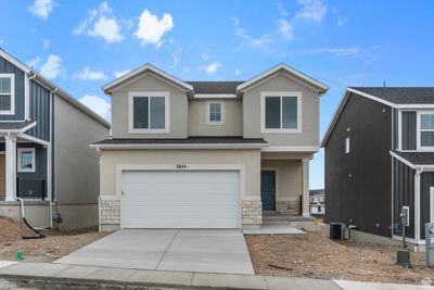 View of front of property with a garage and central AC | Image 1