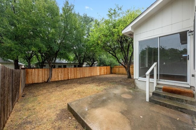 Fenced backyard featuring entry steps and a patio area. | Image 25