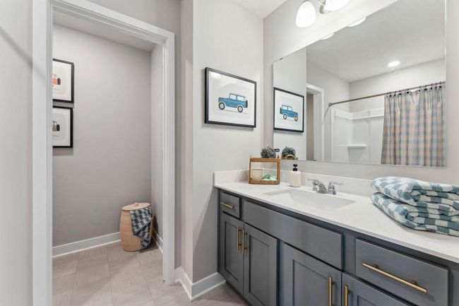 Across the hall from the two secondary bedrooms, this full bath has a separate water closet. Photo of model home, colors and finishes will vary. | Image 34