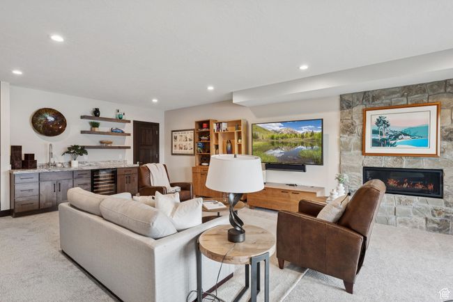 Living room featuring light carpet, wine cooler, recessed lighting, a fireplace, and bar area | Image 47