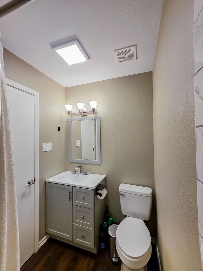 Half bath featuring wood finished floors, toilet, and vanity | Image 16