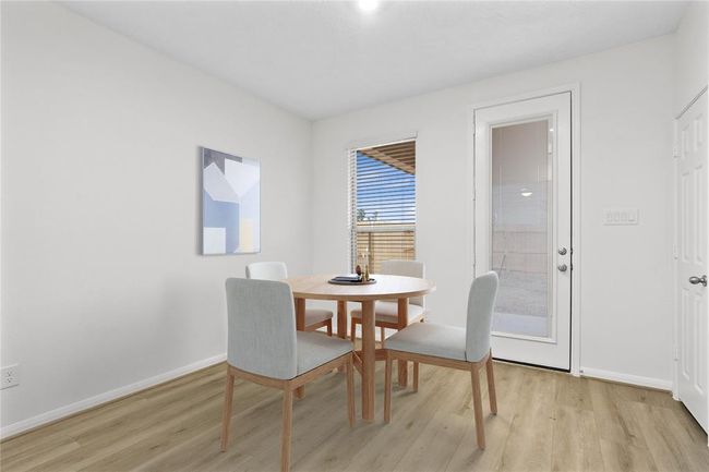Start your day off right with a cup of coffee sitting with your family in the lovely breakfast/dining area! Featuring a large window with privacy blinds, custom neutral paint, vinyl plank flooring, recessed lighting and high ceilings! | Image 10