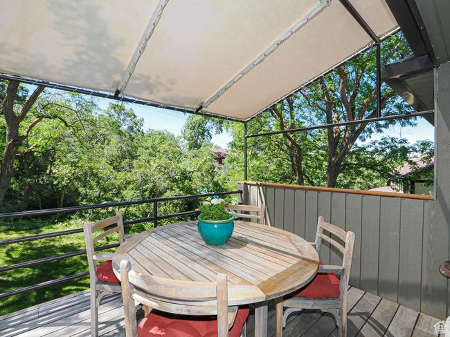 Wooden deck featuring outdoor dining space and view of scattered trees | Image 69