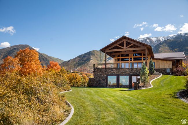 Back of property with stone siding, a lawn, and a mountain view | Image 15