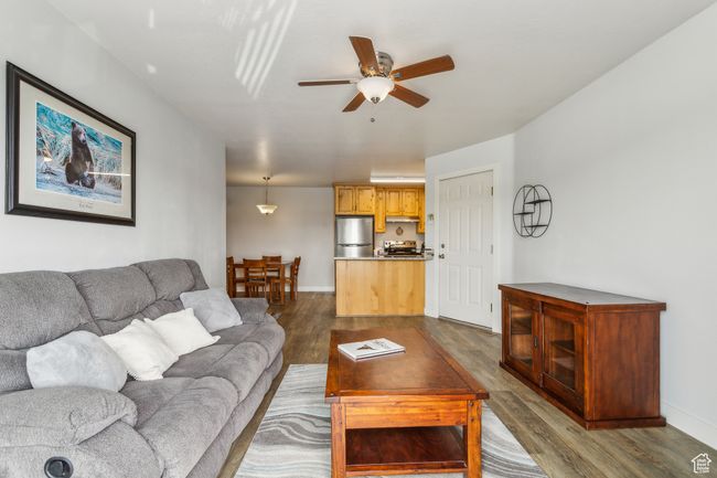 Living area featuring dark wood-type flooring, a ceiling fan, and baseboards | Image 24