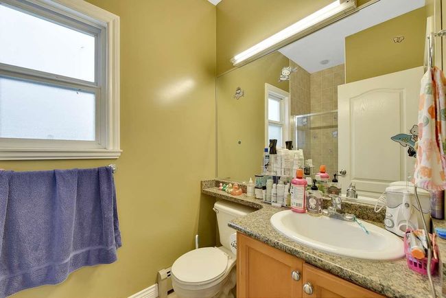 Full bathroom featuring a tile shower, toilet, vanity, and a baseboard radiator | Image 32