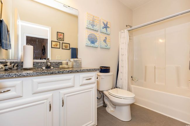 Bathroom featuring shower / tub combo, tile patterned flooring, vanity, and toilet | Image 22