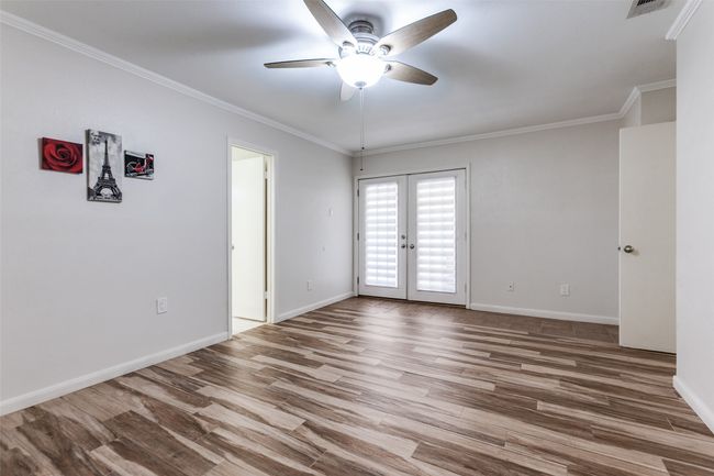 Empty room featuring french doors, ceiling fan, wood finished floors, and crown molding | Image 16