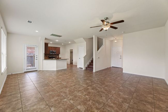 Unfurnished living room with ceiling fan, stairs, recessed lighting, and tile patterned flooring | Image 4