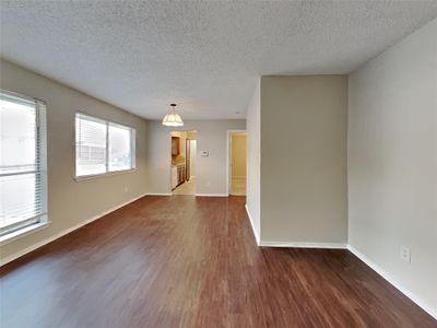 Empty room featuring dark wood-type flooring and a textured ceiling | Image 1