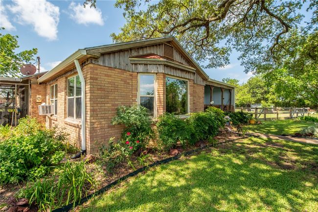 View of side of property featuring brick siding and cooling unit | Image 12