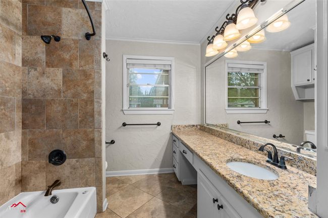 Bathroom with ornamental molding, vanity, tile patterned floors, shower combination, and toilet | Image 12