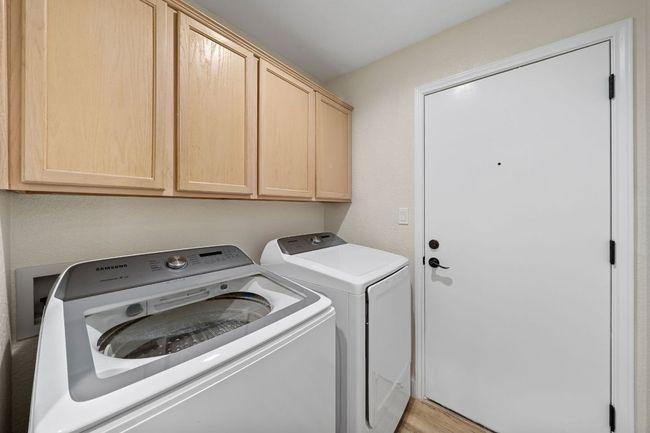 Laundry room featuring washer and dryer, cabinet space, and light wood-style floors | Image 16