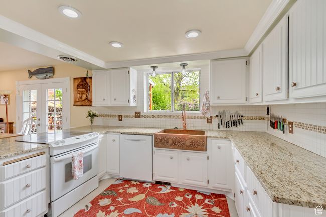 Kitchen featuring a peninsula, a sink, white appliances, and a wealth of natural light | Image 14