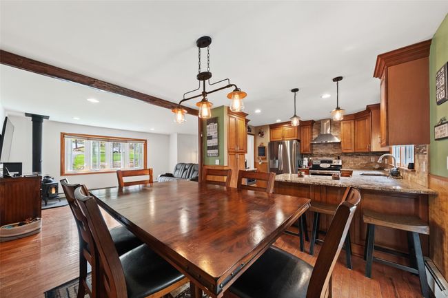 Dining space featuring a wood stove, recessed lighting, baseboard heating, and light wood-type flooring | Image 15
