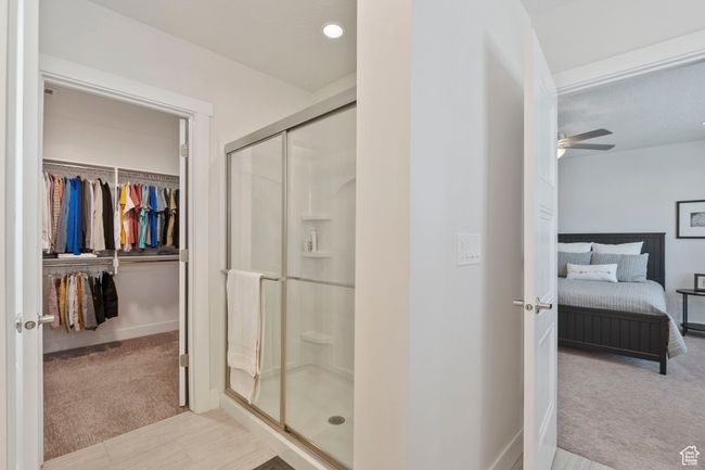 Full bath with a stall shower, a spacious closet, ceiling fan, and ensuite bath | Image 16