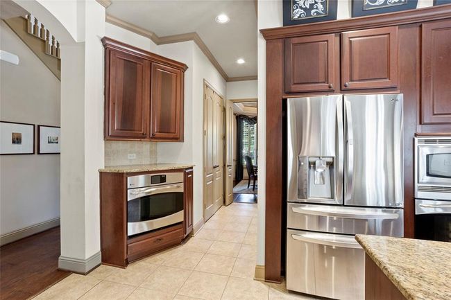 Home has two single ovens. All appliances are GE Profile. Down this hallway is double doors to the pantry and across from a built in MUD room. | Image 12