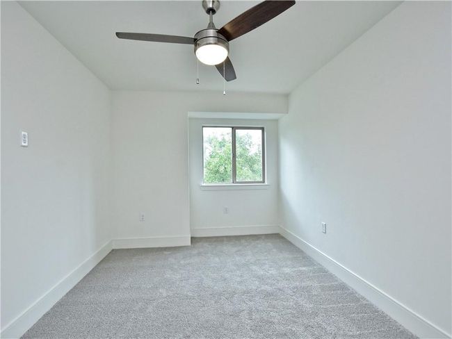 Carpeted empty room with a ceiling fan and baseboards | Image 16
