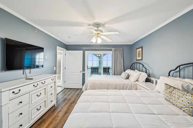 Bedroom featuring access to exterior, crown molding, dark wood-style flooring, and ceiling fan | Image 29