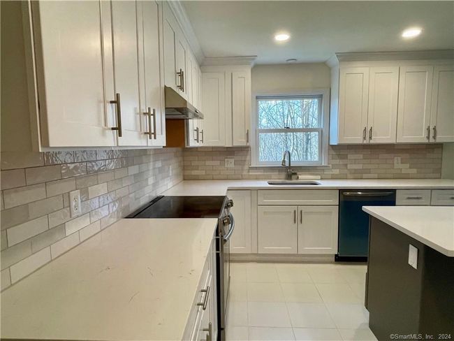 White cabinets to the ceiling with tiled backsplash and tiled floor | Image 6