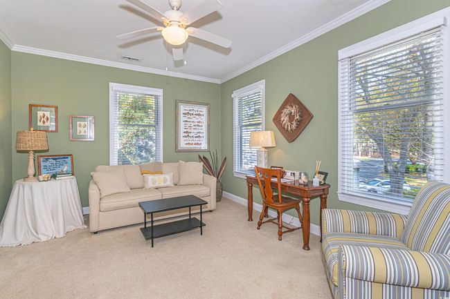 Living area with visible vents, crown molding, baseboards, ceiling fan, and light carpet | Image 29