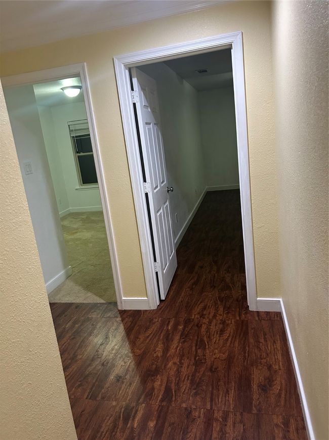 Hallway with wood finished floors and a textured wall | Image 14
