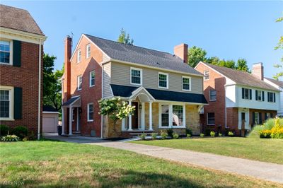 Colonial home featuring an outbuilding, a garage, and a front lawn | Image 2