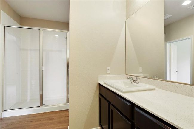 Full bath featuring vanity, a shower stall, and wood finished floors | Image 16