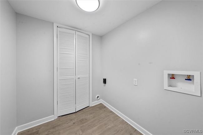 Laundry room featuring hookup for an electric dryer, light wood-style floors, laundry area, hookup for a washing machine, and baseboards | Image 28