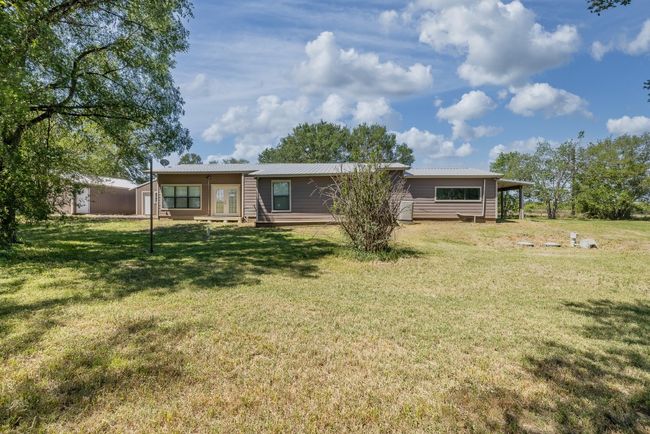 Back of property with french doors, metal roof, and a lawn | Image 38