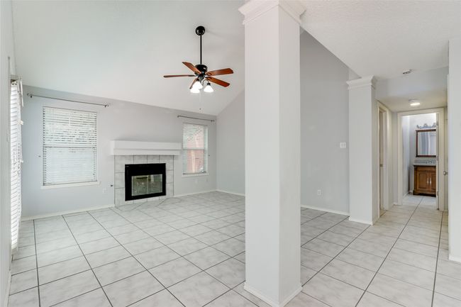 Unfurnished living room featuring a tile fireplace, light tile patterned floors, baseboards, and ceiling fan | Image 8