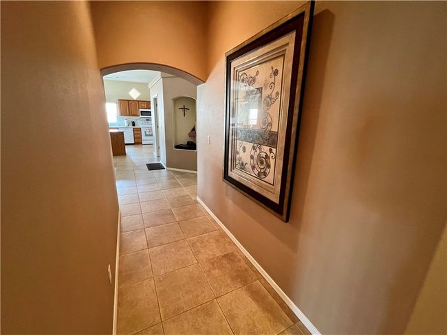 Hallway featuring arched walkways, light tile patterned floors, and baseboards | Image 29