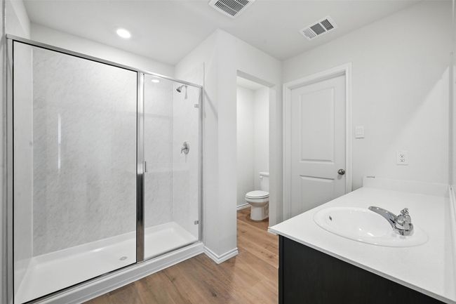 Full bathroom with a shower stall, wood finished floors, vanity, and recessed lighting | Image 17