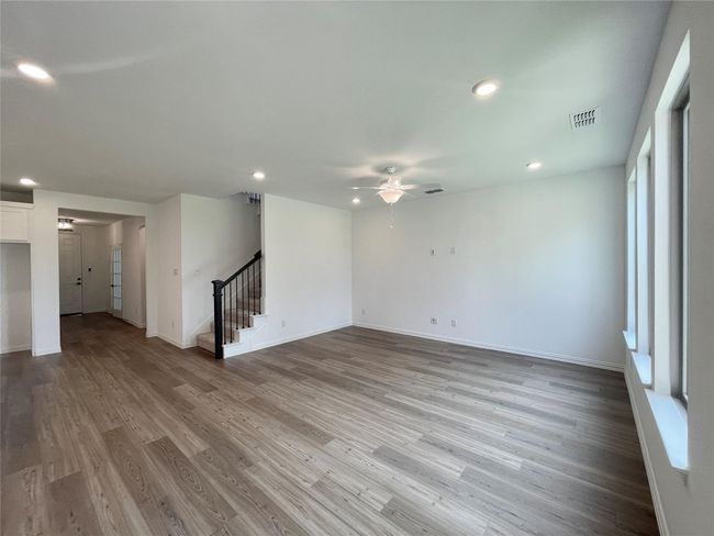 Unfurnished room with ceiling fan, light wood-type flooring, stairway, and recessed lighting | Image 7