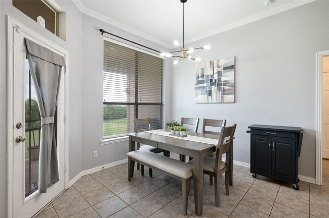 Dining area with light tile patterned floors, a chandelier, and crown molding | Image 20