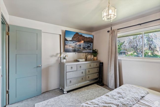 Bedroom with carpet floors and a chandelier | Image 14
