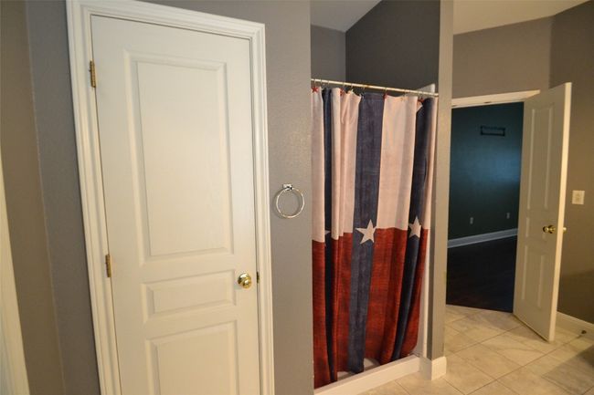 Bathroom featuring curtained shower and tile patterned flooring | Image 14
