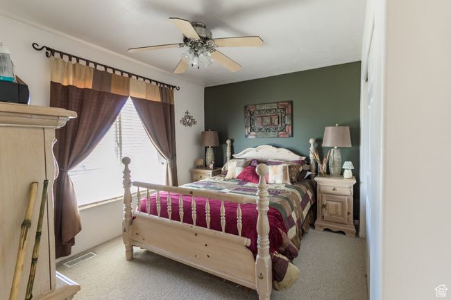 Bedroom featuring visible vents, a ceiling fan, and carpet flooring | Image 20