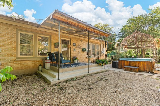 Rear view of property featuring a hot tub, brick siding, and a patio area | Image 29